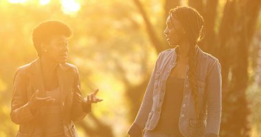 Sokağın ortasında gün ışığıyla konuşan iki kadın.