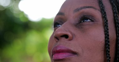 Meditasyon yapan Afrikalı kadın, dışarıyı düşünerek gözlerini kapatıyor.