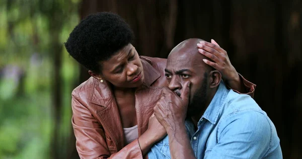 Black woman consoling crying depressed man