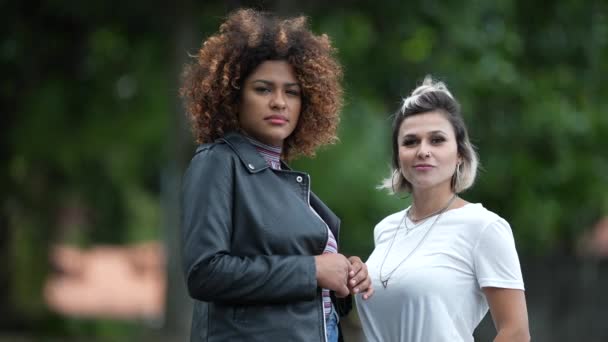 Dos Mujeres Jóvenes Diversas Pie Fuera Mirando Cámara — Vídeos de Stock
