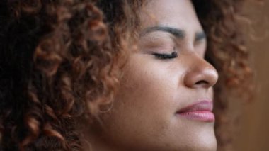 Siyahi kadın meditasyon ve tefekkür için gözlerini kapatıyor.