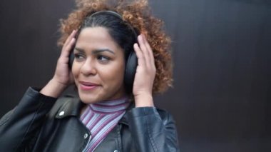 Mutlu Brezilyalı kulaklığı takıp şarkı ve dans dinliyor.