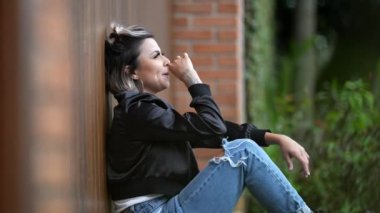 Elleriyle burnunu ve yüzünü kaşıyan bir kadın. İnsan yüzünü ovar.