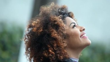 Mutlu Brezilyalı kadın özgürlüğünü hissederek gözlerini gökyüzüne açıyor. Siyah İspanyol kız gökyüzüne bakıyor.