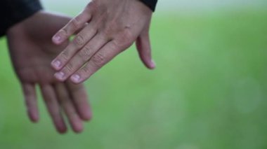 Dışarıda el ele tutuşan iki kişi var.