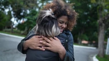 Dışarıda birbirine sarılan iki arkadaş. Dişi arkadaşlar kucaklaşır