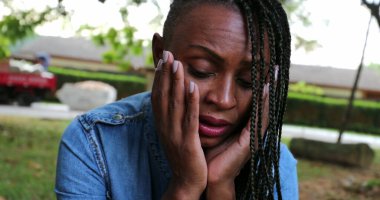 Düşünceli siyah kadın aşağı bakıyor. Endişeli.