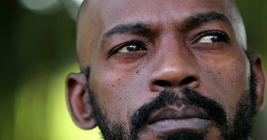 Dalgın Afrikalı adam yakın çekim yüzü. Düşünceli siyah kişi.