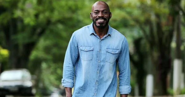 Hayatı kutlayan mutlu Afrikalı adam dans ediyor. Neşeli siyah insan gülüyor