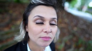  Genç bir kadın meditasyon ve tefekkür yaparken gözlerini kapatıyor. Gökyüzüne gülümseyen bir insan