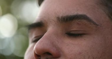Hispanik bir adam gökyüzüne bakıyor, düşüncelere dalmış, Latinlerin mutlulukta gözleri açıp kapanıyor.