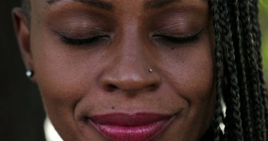 Meditasyon ve tefekkürde gözlerini kapatan bir kadın. Afrikalı gözlerini açıyor