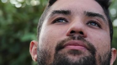 Umutlu ruhlu genç adam gözlerini gökyüzüne açıyor.