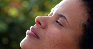 Düşünceli melez kadın meditasyonda gözlerini kapatıyor.