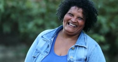 Neşeli Brezilyalı sıradan bir kadın gülümseyip gülüyor. Latin kökenli siyah, mutlu bir insan.