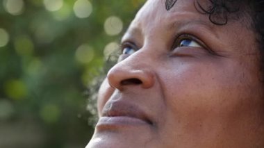 Rahat Afrikalı kadın yüzü dalgınlıkla ufka bakıyor.