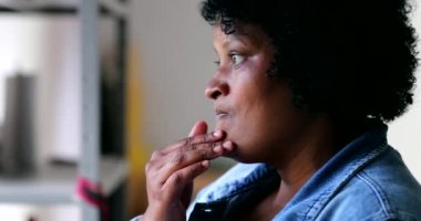 Düşüncelere dalmış dalgın siyah kadın. Pencereden dışarı bakan düşünceli Afrikalı.