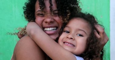 Anne ve kız kucaklaşır. Latin Amerika halkı sevgi ve sevgiyi sever.