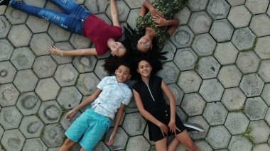 Çocuklar gökyüzünden gökyüzüne bakarak yerde yatıyorlar.