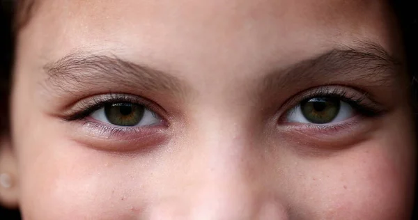 Child closing and opening eyes and smiling, macro green eyes close-up