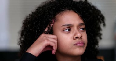 Siyahi küçük kız problem çözmeyi düşünüyor. Düşünceli çocuk.