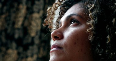 Düşüncelere dalmış meditasyon yapan bir kadın gözlerini kapatır ve açar.