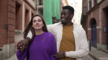 Farklı ırklardan, birbirine aşık genç bir çift sokakta yürüyor.