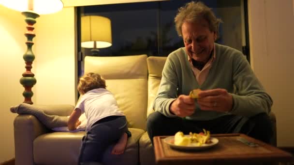 Dziadek Wnuczek Siedzą Razem Salonie Śmiejąc Się Uśmiechając Dziadek Obiera — Wideo stockowe
