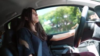 Konuşurken şehirde araba kullanan bir kadın. Sürücü kadın araba kullanırken konuşuyor. Yolda konuşulan kişi