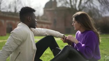 Irklar arası bir çift parkta çimlerin üzerinde birlikte takılıyor.