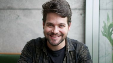 Kameraya gülümseyen genç bir adamın portresi. Yakından bir erkek gülümsemesi kameraya bakar. Milenyum adamı.