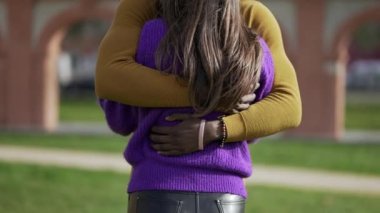 Irklar arası çiftler birbirini sever ve kucaklar. Siyah adam kız arkadaşına sarılıyor, yakın plan eller arkaya.