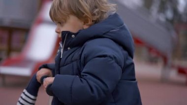 Bebek scooter 'a biniyor. Çocuk parkta üç tekerlekli scooter sürüyor.