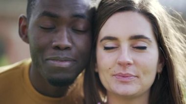 Afrikalı bir adam ve beyaz bir kız gözlerini kapatıyor. Irklar arası çift göz kapalı.