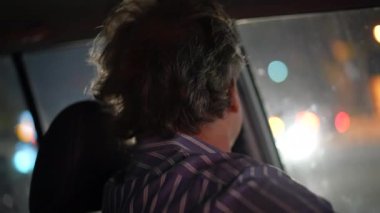 Gece araba süren kıdemli bir adam. Trafiğe girmeyi bekleyen biri var. Şehir merkezindeki olgun yaşlı erkek sürücünün yakın plan yüzü..