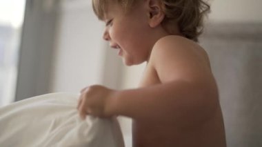 Bebek çarşafları çekiyor.