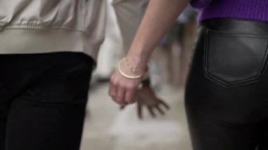 Siyah adam beyaz kız arkadaşıyla el ele tutuşuyor.