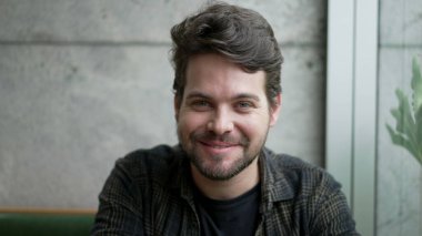 Yakışıklı adam portresi, yakından gülümsüyor. 30 'lu yaşlarda biri kameraya bakıyor.