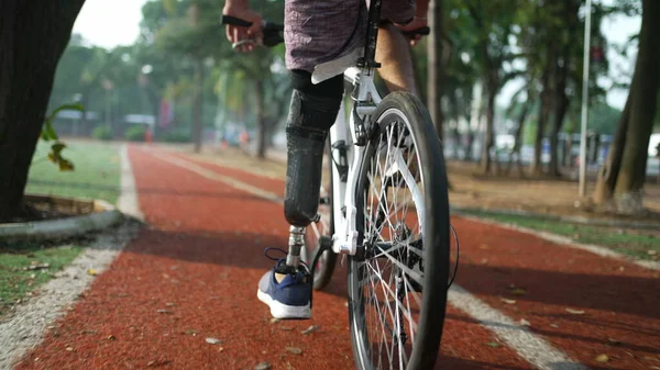 在户外使用义肢骑自行车的残疾人 — 图库照片