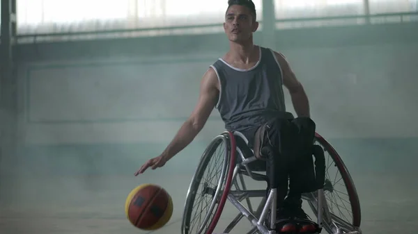 A disabled athlete in wheelchair playing basketball. Handicapped sportman