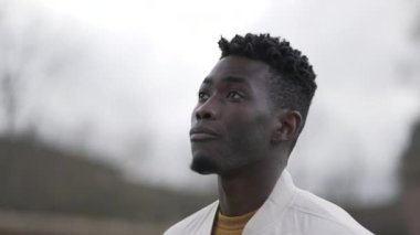 Dışarıda dolaşan düşünceli bir Afrikalı. Düşünceli meditasyon yapan kişi hayal kuruyor.