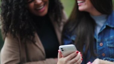 Çeşitli arkadaşlar cep telefonuna bakıp birlikte gülüyorlar.