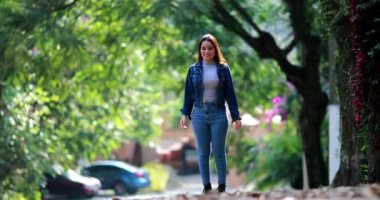 Dışarıda sevinçten havalara uçan heyecanlı kız. Yirmili yaşlarda genç bir kadın kutlama yapıyor.