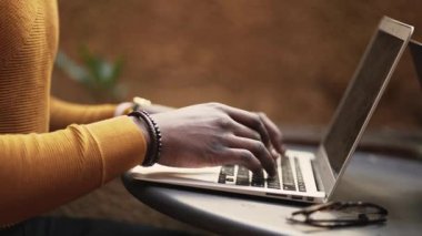 Genç siyahi Afrikalı girişimci dizüstü bilgisayarla çalışıyor