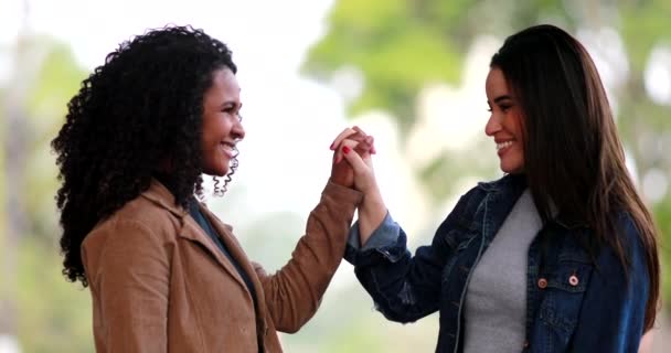 二人の多様な若い女性が手を取り合い 黒と白の女の子が手を合わせ 多様性の概念 — ストック動画