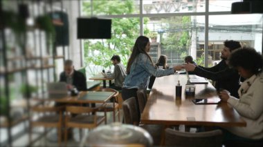 Kahve dükkanındaki müşteriler. Kafe restoranındaki erkek arkadaşına espresso getiren bir bayan arkadaş.
