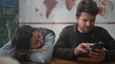 Kahve dükkanında oturan canı sıkkın kız arkadaşıyla telefonda konuşan bir adam. Teknolojik modern baloncuk kavramı