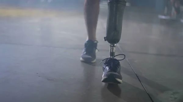 Disabled person walking with his prosthetic leg indoors. Amputee man walks with prosthetis legDisabled person walking with his prosthetic leg indoors. Amputee man walks with prosthetic leg