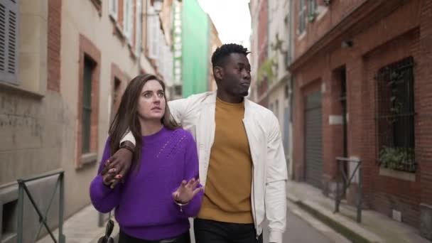 若いロマンチックな異人種間のカップルがヨーロッパの都市の外を歩く — ストック動画