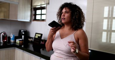 Siyah kadın akıllı telefonuyla sesli mesaj gönderiyor.